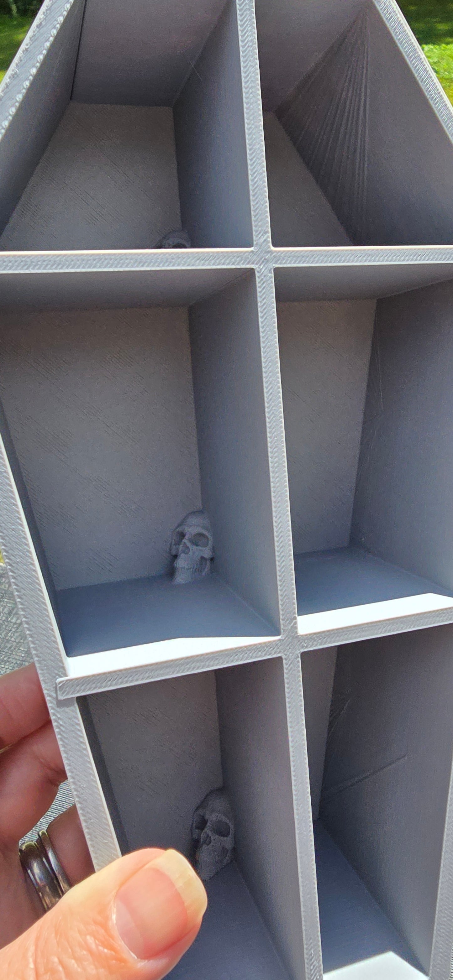 3D-Printed skull coffin shaped shelf.