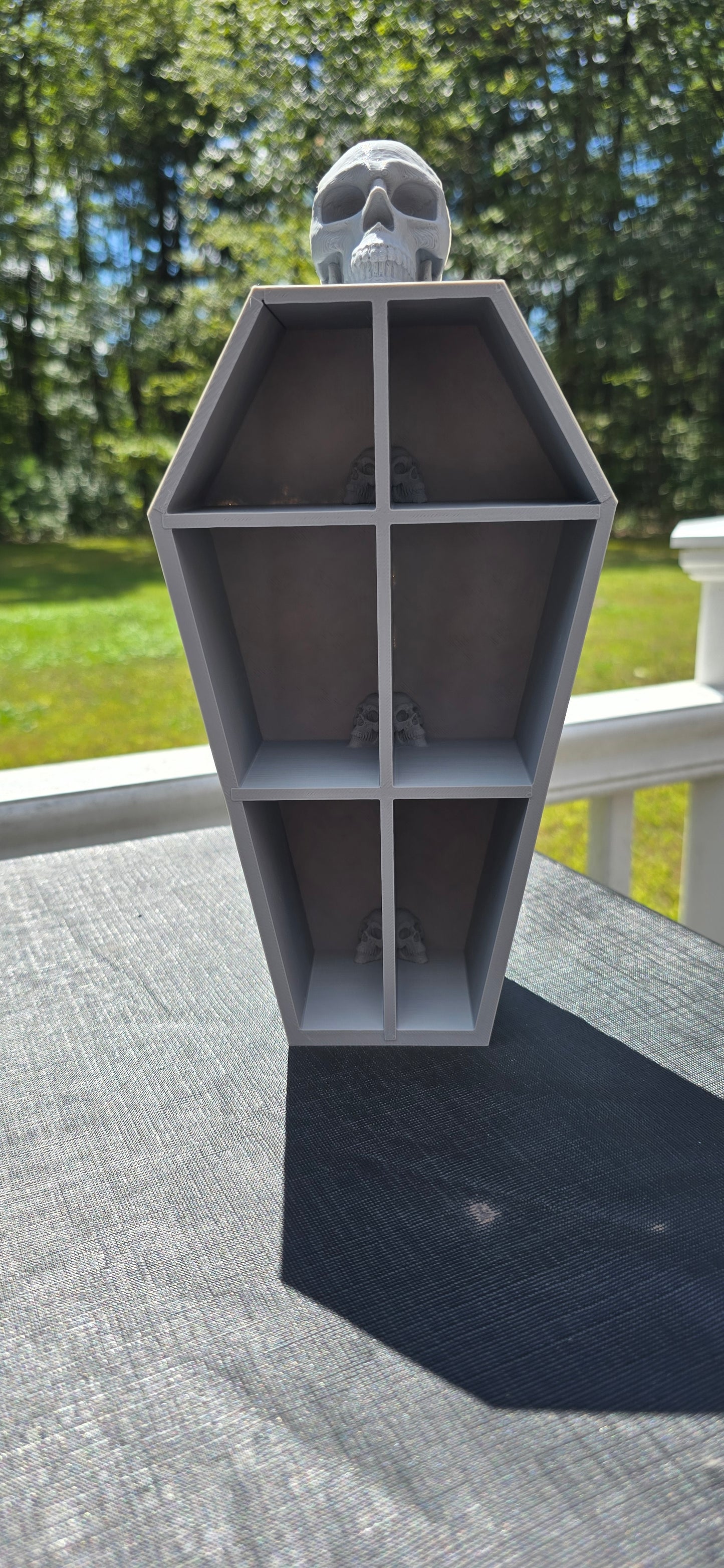 3D-Printed skull coffin shaped shelf.