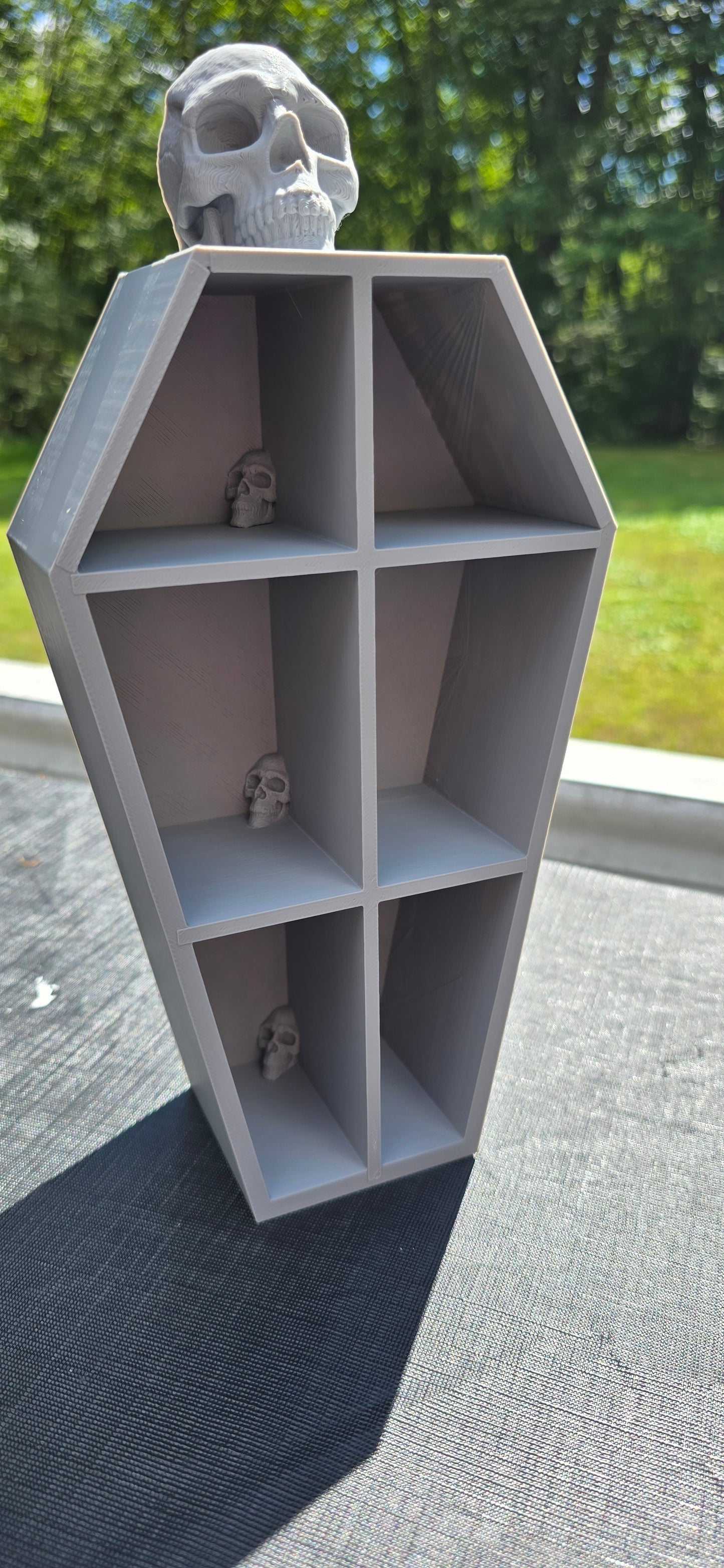 3D-Printed skull coffin shaped shelf.